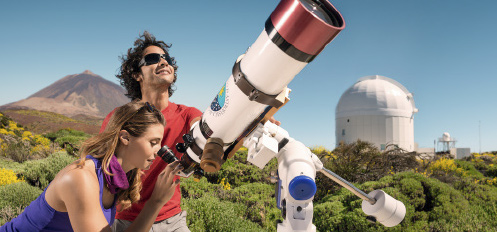 Couple observing through a telescope on Teide